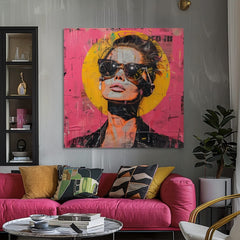 Slika na platnu z motivom ženska s sončnimi očali, roza in rumena obešena v sodobnem stilskem interjerju nad leseno konzolo z vazo in svečo, Papilora.