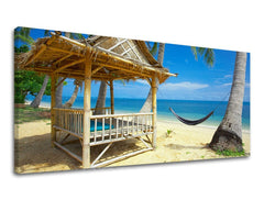 Slika na platnu z motivom bambusova koča na peščeni plaži – 3D prikaz platna z vidnim lesenim okvirjem, Papilora.