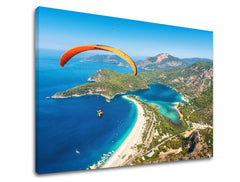 Slika na platnu z motivom padalec nad modro laguno in plažo – 3D prikaz platna z vidnim lesenim okvirjem, Papilora.